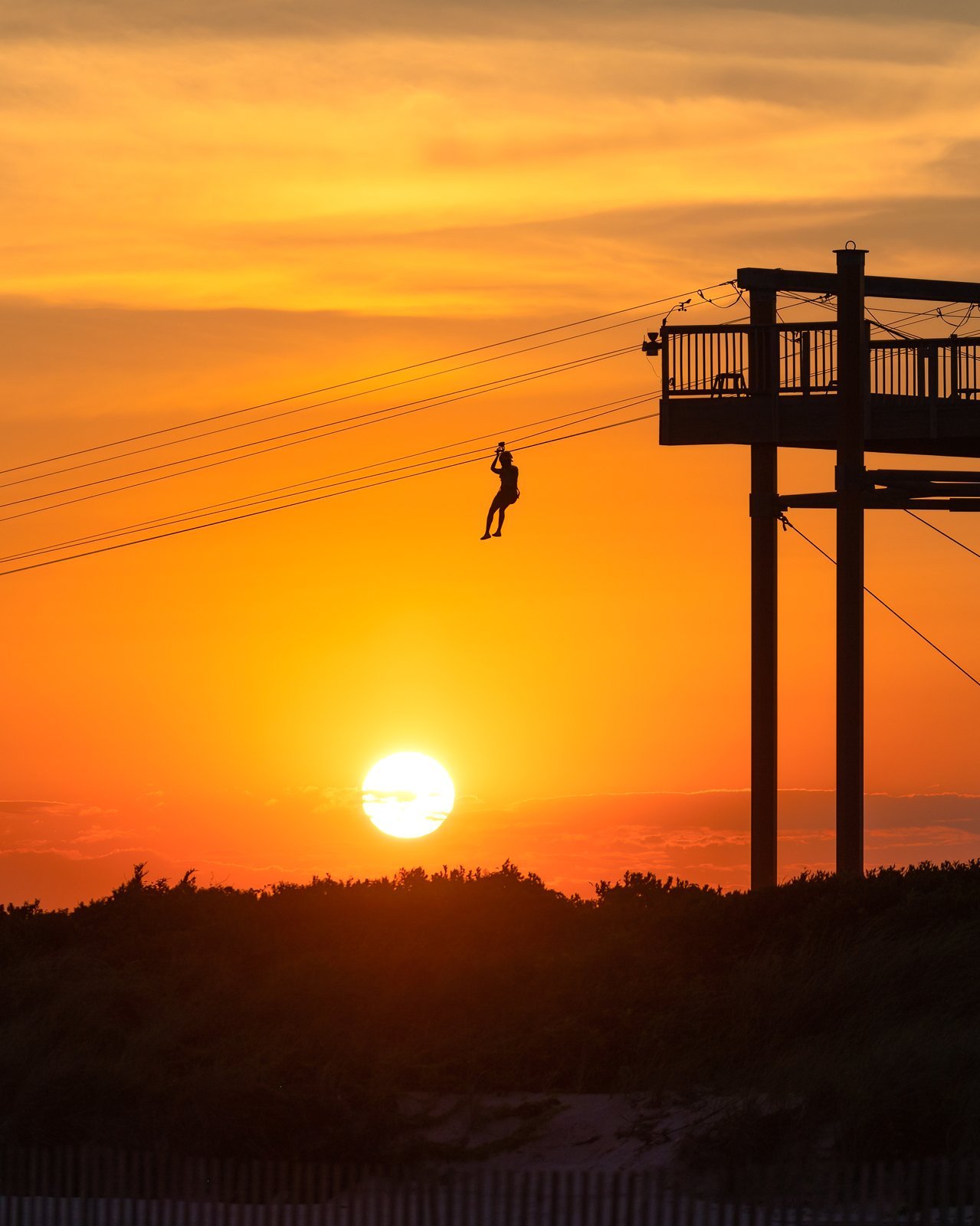 Sunset zip line over Baja, rider on the cable